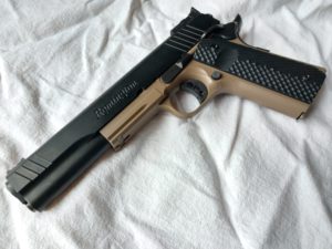 Remington 1911-style semi-automatic handgun in two-tone black and Flat Dark Earth (FDE) lying on a wrinkled white cloth background.