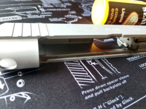 Dirty slide rail cuts inside a silver slide of a field-stripped Glock 48 9mm self-defense pistol