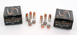 Two black boxes of Speer brand Gold Dor personal protection 9mm handgun ammo, plus six full cartridges with copper hollow-point bullets and nickel casings. Nearby are six flattened bullets.