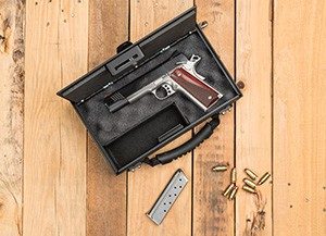 Console Vault Gun Transporter open on a table with a magazine and cartridges next to it